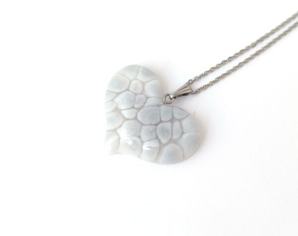 Floating stones in pale grey color, resin heart pendant