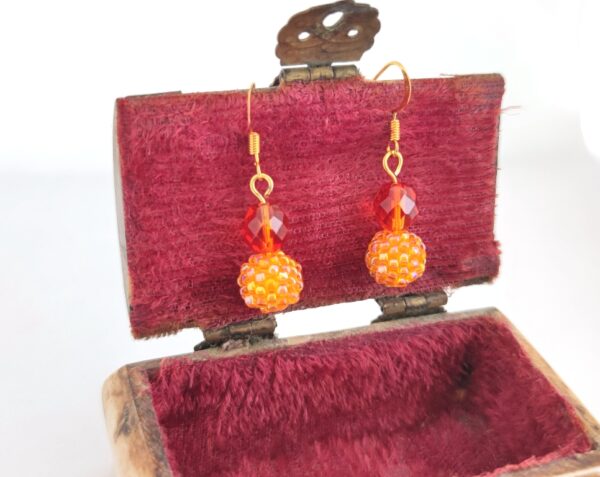 Long earrings with beaded beads in orange color