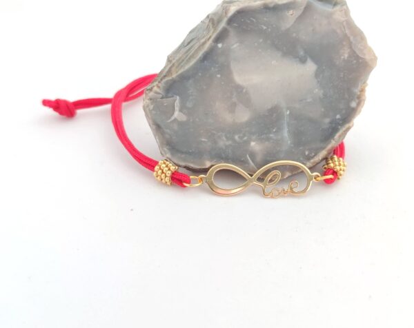 Cord bracelet with a gold love sign pendant