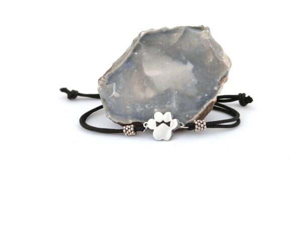 Cord bracelet with a silver color paw pendant in black