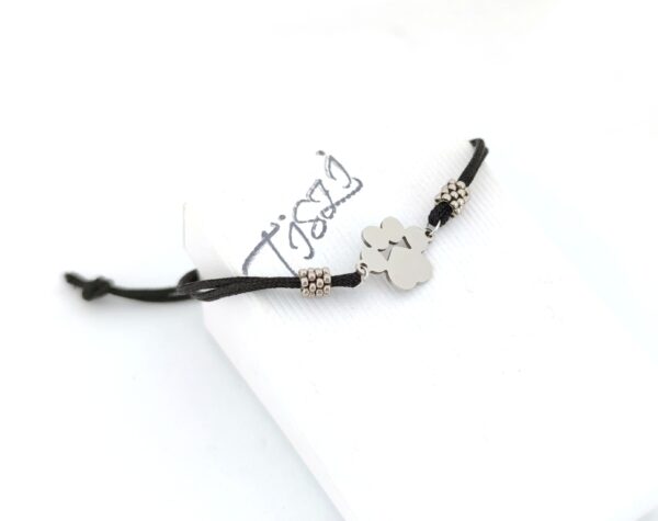 Cord bracelet with a silver color paw pendant in black
